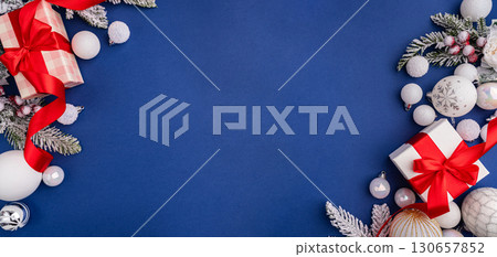 White Christmas Gift with Red Ribbon and Ornaments on Blue 130657852