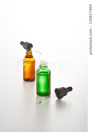 Green, amber mini bottles mockups with pipettes. Green, amber mini bottles mockups with pipettes. 130657964
