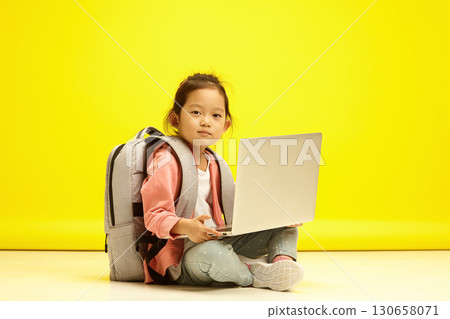 Studios Korean Child girl with Laptop on sits over Bright Yellow background Studios Korean Child girl with Laptop on sits over Bright Yellow background 130658071