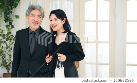 A middle-aged couple walking in front of a shop 130658586