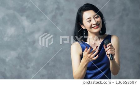 女歌手用麥克風唱歌 130658597
