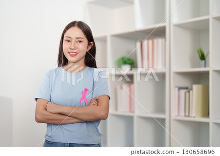 Breast Cancer Awareness. Young woman confidently posing with pink ribbon. 130658696