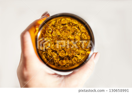 Hand Holding Bottle of Omega-3 Capsules for Health and Nutrition Hand Holding Bottle of Omega-3 Capsules for Health and Nutrition 130658991