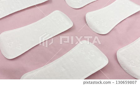 Womens sanitary pads on pink background, top view. Feminine hygiene and menstruation product. Daily pad for period care, women's health, advertising, article or banner concept, background 130659807