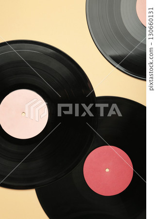 Vinyl record on beige background. Vertical photo Vinyl record on beige background. Vertical photo 130660131