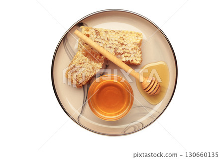 Bowl of sweet honey, dippers and combs on plate isolated on white background. 130660135