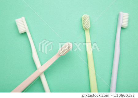 Pastel toothbrushes on mint background. Dental health and hygiene concept 130660152