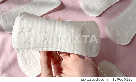 Woman hand holding daily pad on pink background. Female menstruation, cycle, hygiene concept. Gynecology 130660183