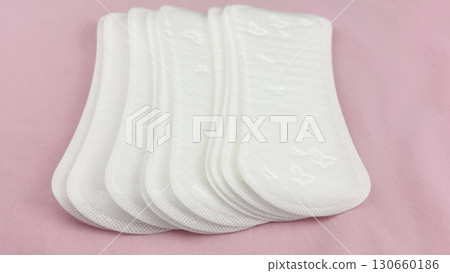 Womens sanitary pads on pink background, top view. Feminine hygiene and menstruation product. Daily pad for period care, womens health, advertising, article or banner concept 130660186