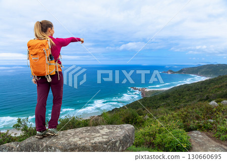 Young woman with backpack on the mountain top Young woman with backpack on the mountain top 130660695
