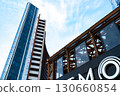 A Stunning Architectural View Featuring a Modern Tower Against a Clear Sky with a Unique Structure and Intricate Design Elements in the Foreground 130660854