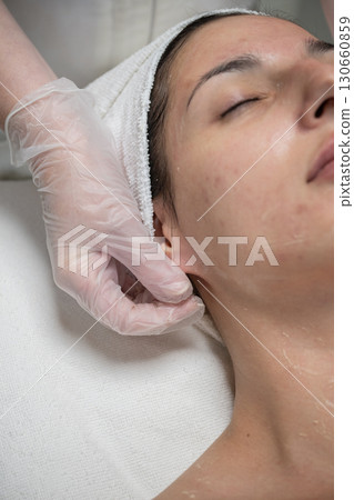 Beautician performing facial skincare treatment for female client in beauty salon Beautician performing facial skincare treatment for female client in beauty salon 130660859