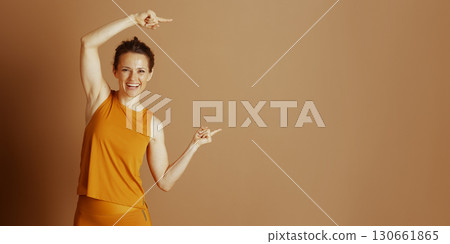 Pointing the Way: Cheerful Woman in Orange Pointing the Way: Cheerful Woman in Orange 130661865