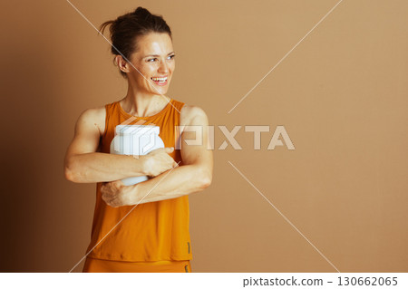 Health Enthusiast in Orange with Supplement Jar 130662065