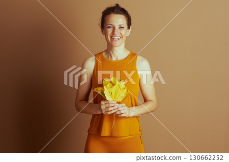 Joyful Woman with Autumn Leaves in Activewear Joyful Woman with Autumn Leaves in Activewear 130662252