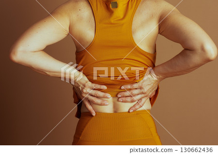 Adult with Lower Back Pain in Orange Activewear 130662436
