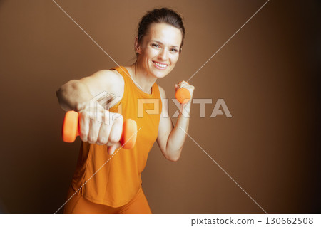 Energetic Woman with Dumbbells in Dynamic Pose Energetic Woman with Dumbbells in Dynamic Pose 130662508