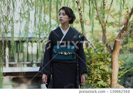 一位身著和服的女子在日式花園的橋上，柳樹下擺姿勢 | 日本傳統服飾與美麗 130662568