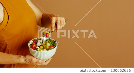 Woman Enjoying Healthy Salad for Wellness 130662656
