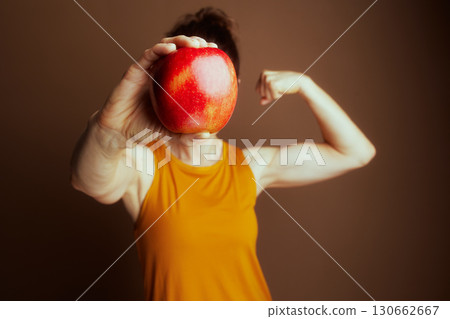 Strong Woman Hides Behind a Healthy Red Apple 130662667