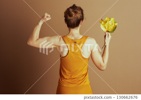 Strong Woman Flexing with Autumn Leaves 130662676