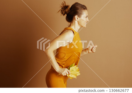 Vibrant Autumn Stride: Woman with Fall Leaves Vibrant Autumn Stride: Woman with Fall Leaves 130662677