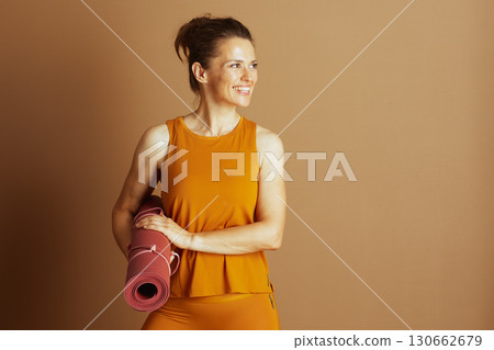 Smiling Woman in Yellow with Deep Pink Yoga Mat 130662679
