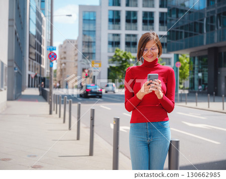 Woman in glasses stands in center of Frankfurt, 130662985