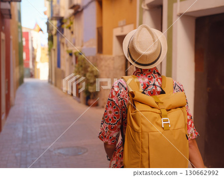 Woman strolls through colorful streets of Spanish coastal town Woman strolls through colorful streets of Spanish coastal town 130662992