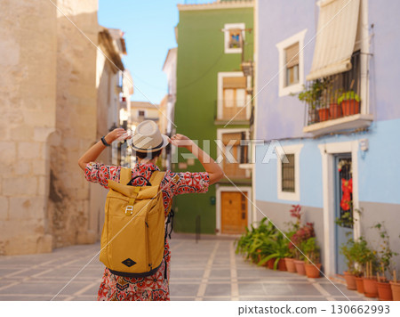 Woman strolls through colorful streets of Spanish coastal town Woman strolls through colorful streets of Spanish coastal town 130662993