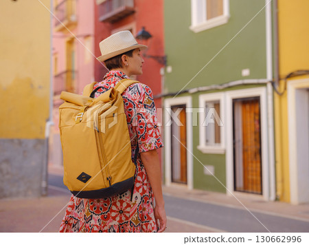 Woman strolls through colorful streets of Spanish coastal town 130662996