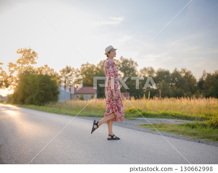 boho chic woman in a floral dress in European countryside boho chic woman in a floral dress in European countryside 130662998