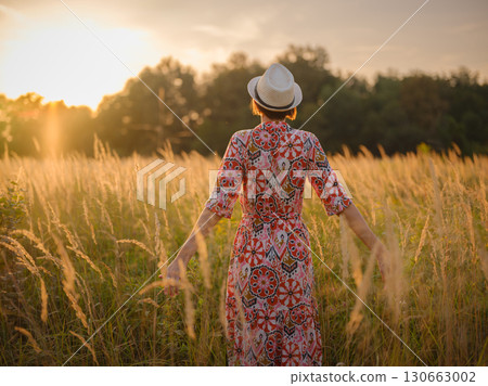 boho chic woman in a floral dress in European countryside boho chic woman in a floral dress in European countryside 130663002