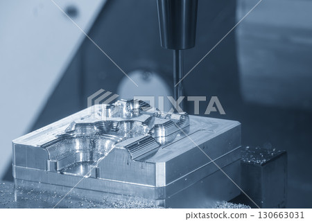 The 3-axis CNC milling machine cutting the mold part with solid flat nose end mill tool in the blue tone. The 3-axis CNC milling machine cutting the mold part with solid flat nose end mill tool in the blue tone. 130663031