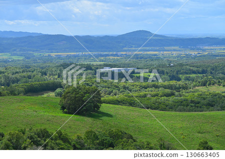 A rural town in Hokkaido overlooked from a ranch hill overlooking the mountain ridges A rural town in Hokkaido overlooked from a ranch hill overlooking the mountain ridges 130663405