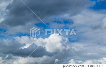 A beautiful white cumulus cloud is illuminated by the sun A beautiful white cumulus cloud is illuminated by the sun 130663415
