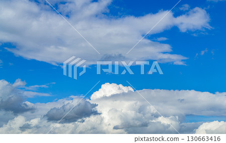 A beautiful white cumulus cloud is illuminated by the sun 130663416