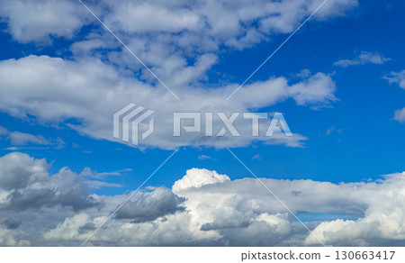 A beautiful white cumulus cloud is illuminated by the sun 130663417