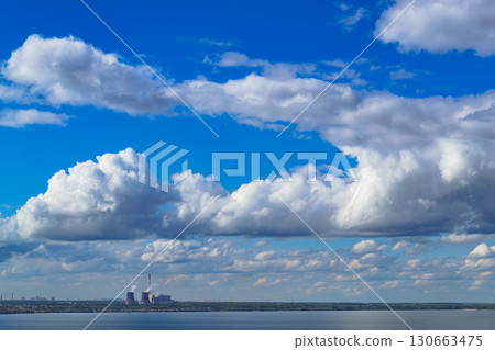 Industrial power plant by lake under blue sky Industrial power plant by lake under blue sky 130663475