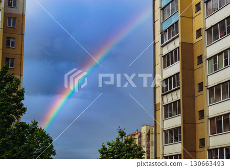 Rainbow between apartment buildings in city 130663493