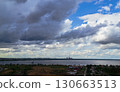 Storm clouds over lake and industrial skyline 130663513