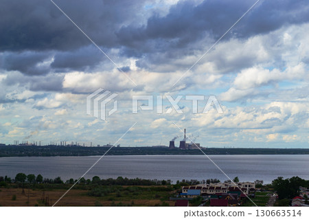 Storm clouds over lake and industrial skyline Storm clouds over lake and industrial skyline 130663514