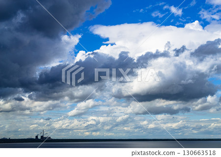 Storm clouds over lake and industrial skyline with power plant Storm clouds over lake and industrial skyline with power plant 130663518