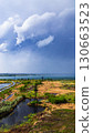 Thunderclouds over the lake and the road in the middle of the field 130663523
