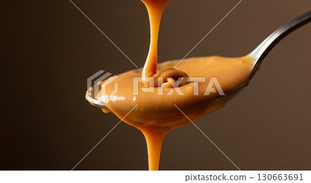 Spoon with Dripping Smooth Peanut Butter 130663691