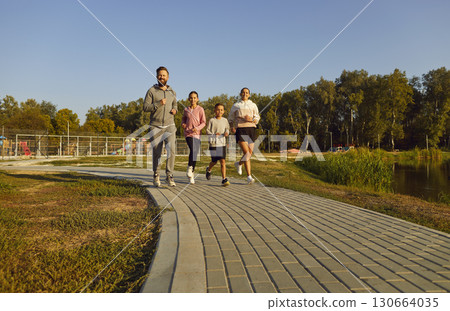 Team of young family with kids running together in the park having sport workout outdoors. 130664035