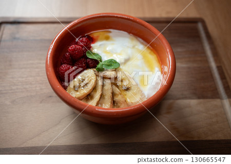 Yogurt with bananas and raspberries makes a delightful breakfast  130665547