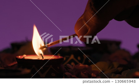 Diwali Silhouette hand lights a candle to celebrate Indian culture Diwali Silhouette hand lights a candle to celebrate Indian culture 130665948