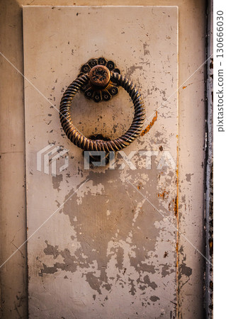 Old rustic door handle in Rome's historic center with weathered paint Old rustic door handle in Rome's historic center with weathered paint 130666030