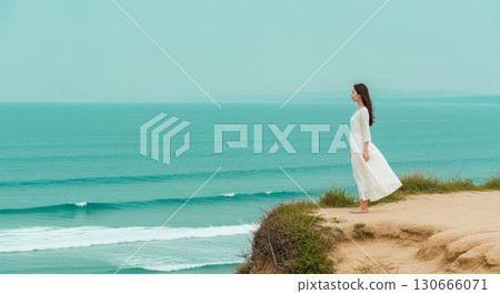 Woman standing on a cliff by the sea Woman standing on a cliff by the sea 130666071